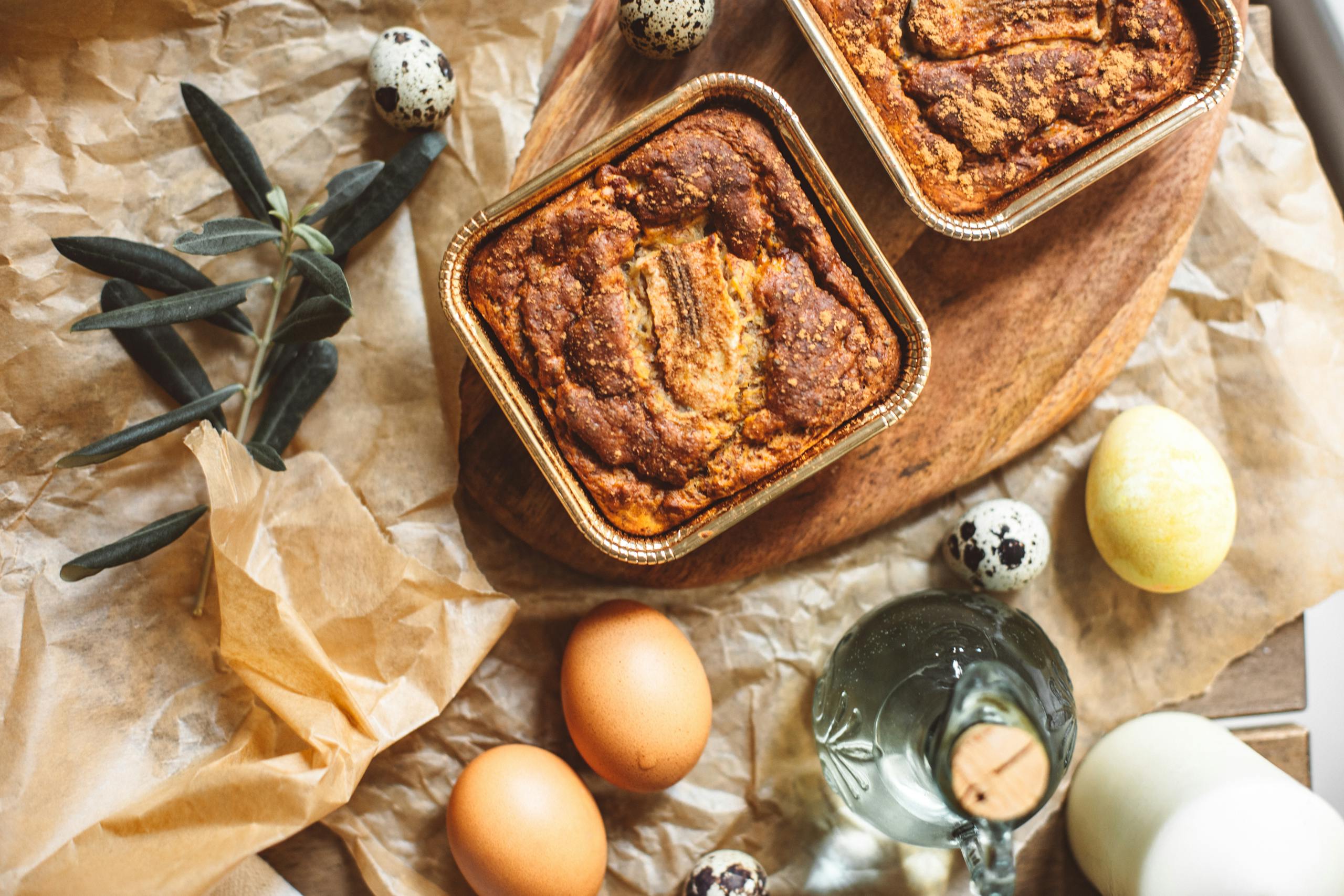 Delicious homemade banana bread with eggs and ingredients on a rustic kitchen table.