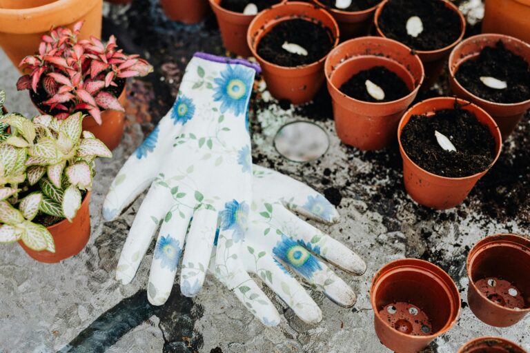 Floral gloves and potted plants on a table, perfect for home gardening inspiration.